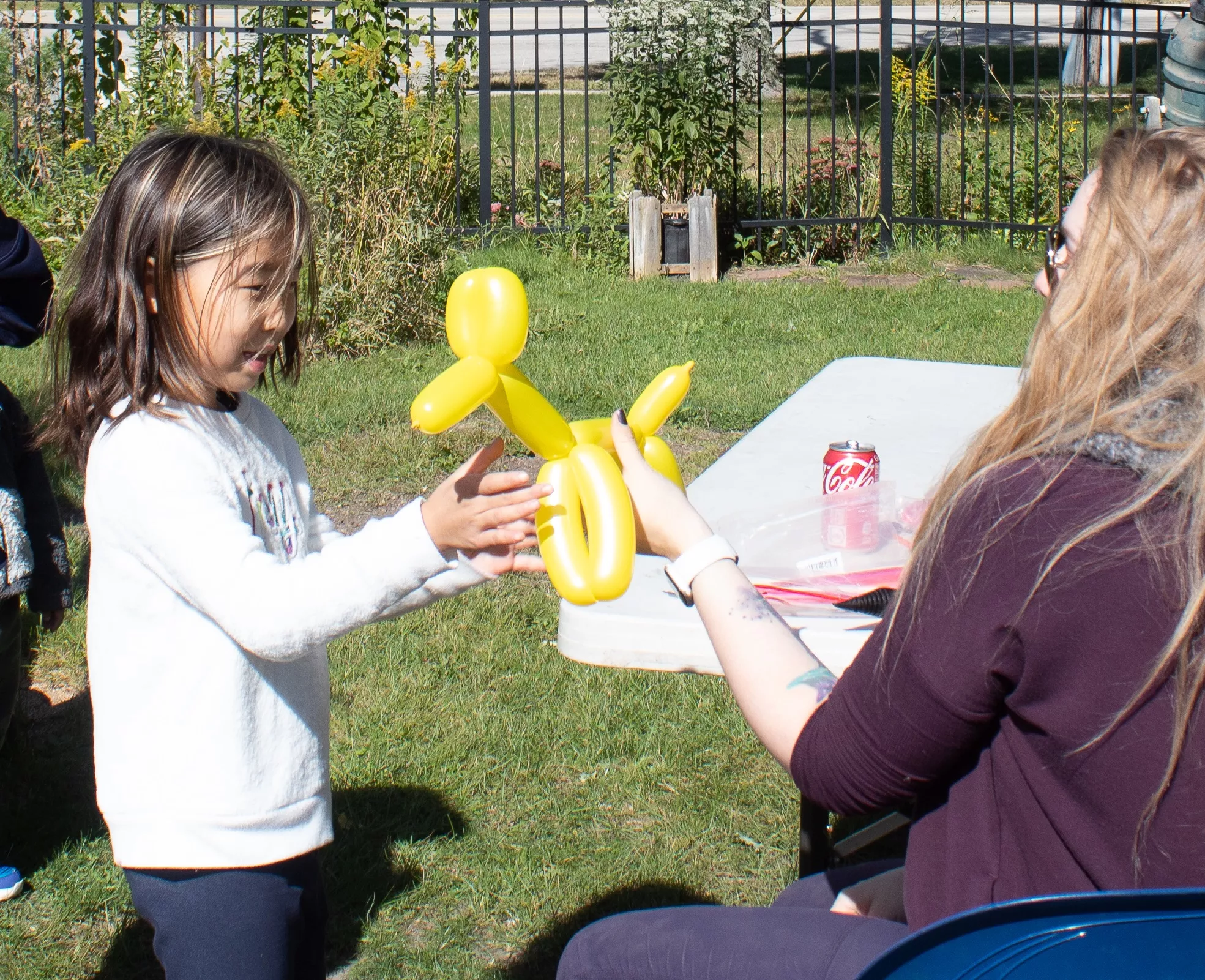 Child getting a yellow balloon animal